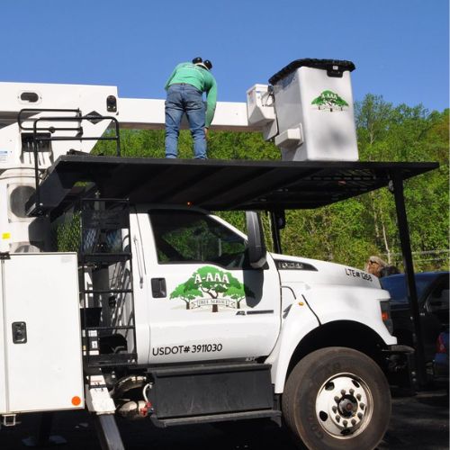 A member of the A-AAA Tree Service team preparing the bucket truck for commercial work in the Greater Baltimore Area.